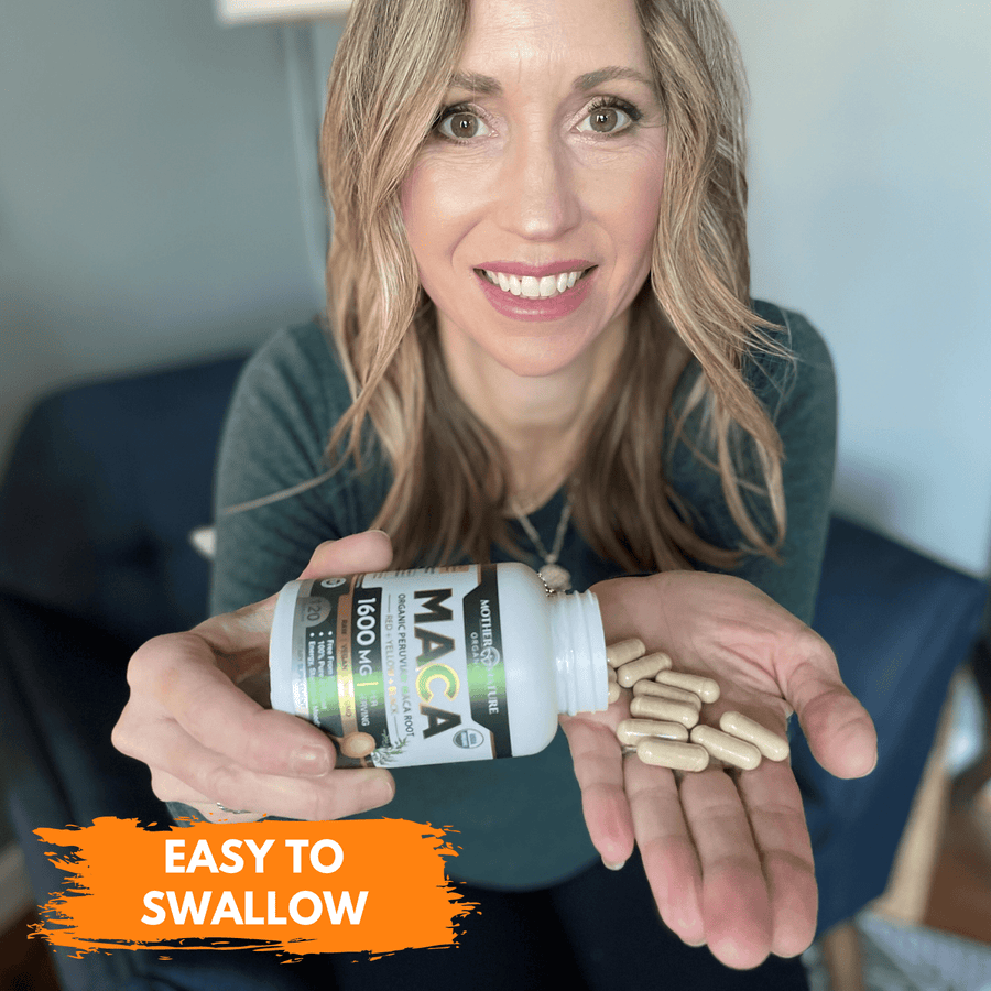 Hand holding a bottle of Mother Nature Organics Maca Root Capsules with capsules in the palm